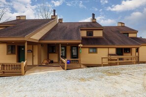 A two-story building with a covered porch, a green door, and a sign reading '19'. - Two Okemo condos - ski-in/ski-out - pool, fast WiFi, washer/dryer (Ludlow)