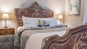Un dormitorio con una cama grande, dos mesitas de noche y un cuadro enmarcado en la pared.
