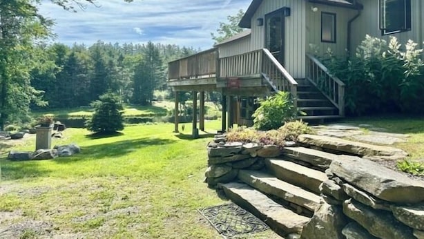 A two-story house with a porch, a stone staircase, and a well-maintained lawn. - Tranquil house w/ pond, 3-hole golf course, sandy beach, bbq, firepit, & trails (Londonderry)
