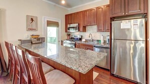 A kitchen with granite countertops, wooden cabinets, stainless steel appliances, and a dining area with chairs. - Renovated condo w/ shared tennis - walk to trail (Ludlow)
