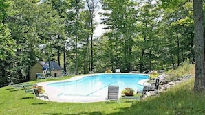 A swimming pool surrounded by grass and trees, with lounge chairs and a small building in the background. - Renovated condo w/ shared tennis - walk to trail (Ludlow)