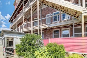 Ein mehrstöckiges Gebäude mit Balkon, Ziegelvorfront und roter Außenwand.