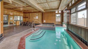 Ein Poolbereich mit Holzboden, einem kleinen Pool und einer Sitzgelegenheit mit Tischen und Stühlen.