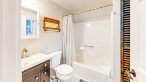 A bathroom with a toilet, sink, and shower.