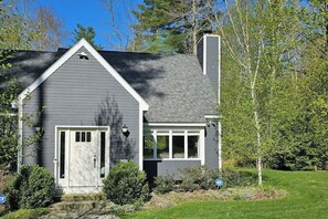 A residential house with a grey exterior, a white front door, and a small porch. - Peaceful mountain home near skiing, hiking, mtn biking & more (Jamaica)