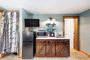 A compact kitchen with a refrigerator, microwave, coffee maker, and a flat-screen TV. - Slope-side condos with kitchenette & streaming (Ludlow)