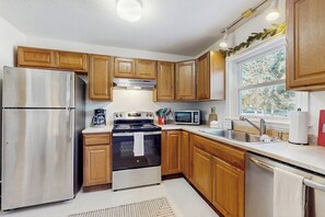 A kitchen with wooden cabinets, stainless steel appliances, a window with a view, and a sink. - Skiers apartment, walk to lifts at Sundance Resort, mountain views, shuttle, w/d (Dover)