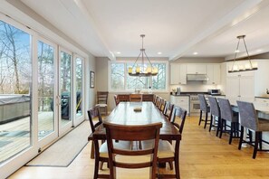 A spacious kitchen with a large dining table, ample natural light, and a view of the outdoors. - Ski-in/out home with a hot tub, fireplace, cable & golf nearby (Ludlow)