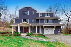 A two-story house with a front porch, a garage, and a stone pathway leading to the entrance. - Ski-in/out home with a hot tub, fireplace, cable & golf nearby (Ludlow)