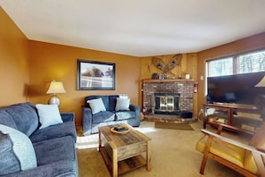 A living room with two sofas, a coffee table, a fireplace, and a television. - Ski-in/out Condo on Bull Run Trail with fireplace, & full kitchen (Ludlow)