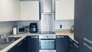 A compact kitchen with a microwave, coffee maker, oven, and stainless steel sink. - Entire rental unit in London, United Kingdom (London)