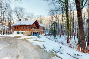 A log cabin with a porch and a staircase leading to the entrance. - Beautiful home near lifts with wood-burning fireplace, mountain views & cable (Ludlow)