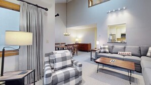Un salon comprenant un canapé, un fauteuil, une table basse et un coin repas avec une table et des chaises.