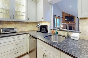 Eine Küche mit Einbau-Toaster, Kaffeemaschine und Spüle.