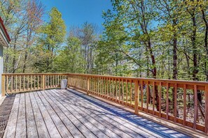 A wooden deck with a railing, surrounded by trees. - Inviting Okemo ski mountain home, two house walk to ski slope! (Ludlow)