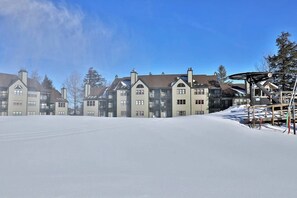 A row of multi-story buildings with a snow-covered ground, likely a hotel or residential complex. - Ski-in/out condo with fireplace, hot tubs. pool, tennis & washer/dryer (Ludlow)