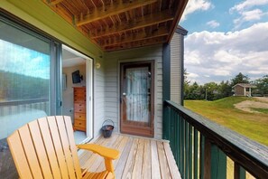 A wooden deck with a sliding glass door leading to a room with a dresser and a chair. - Ski-in/out condo with fireplace, hot tubs. pool, tennis & washer/dryer (Ludlow)