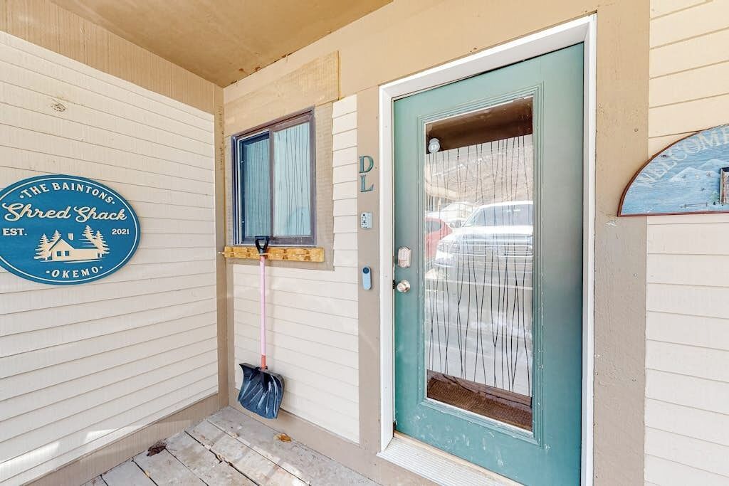 A front door with a glass panel, a wooden door frame, and a sign on the wall.