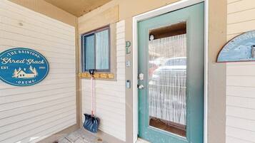 A front door with a glass panel, a wooden door frame, and a sign on the wall.