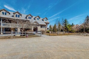 A multi-story residential building with a covered porch and a gravel driveway. - Ski-in/out condo with pool, 2 hot tubs, sauna - short walk to Solitude clubhouse (Ludlow)