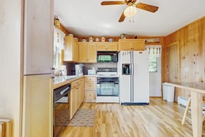 A kitchen with wooden cabinets, a microwave, a stove, a refrigerator, and a ceiling fan. - Quiet country home w/ large deck & fireplace, near Okemo Mtn & town (Ludlow)