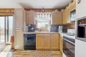 A compact kitchen with wooden cabinets, a dishwasher, a stove, and a window with a view. - Quiet country home w/ large deck & fireplace, near Okemo Mtn & town (Ludlow)