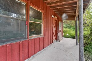 A red wooden building with large windows and a covered porch.