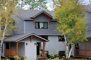 Ein zweistöckiges Haus mit Veranda und kleiner Terrasse.
