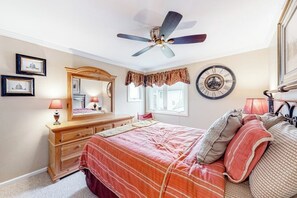 A bedroom with a bed, dresser, ceiling fan, clock, and framed pictures on the wall. - Mountain-view condo with skiing nearby, pool, and balcony - snowbird-friendly (Ludlow)