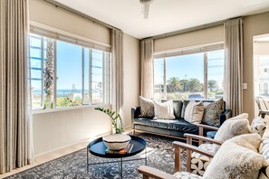 Ein geräumiges Wohnzimmer mit einer Couch, einem Couchtisch und Meerblick.