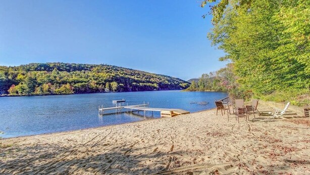 A lakeside beach with a dock, chairs, and a hammock. - Two-story condo with forest views, Echo Lake beach access, pool, dock & tennis (Plymouth)