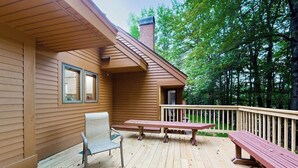 A wooden deck with a bench and a chair, a small table, and a railing. - Two-story condo with forest views, Echo Lake beach access, pool, dock & tennis (Plymouth)