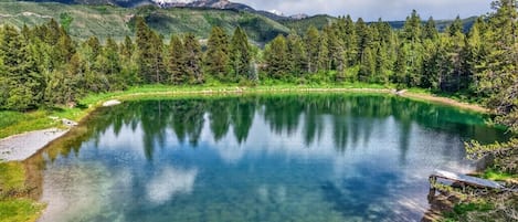 A clear lake surrounded by green hills and trees.