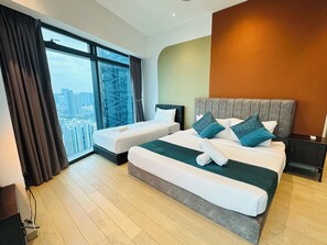 Ein modernes Hotelzimmer mit einem großen Bett, zwei Einzelbetten, Blick auf eine Stadtansicht und einem großen Fenster.