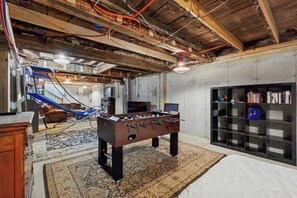 A room with a foosball table, a bookshelf, and a hammock. - Dog-Friendly cottage w/ close to Okemo Resort, firepit, bbq, swimming hole, w/d (Cavendish)