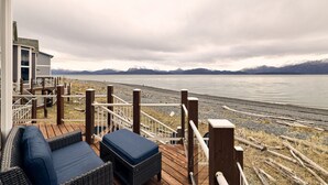 Eine Terrasse mit Sitzgelegenheiten mit Blick auf einen See und Berge.