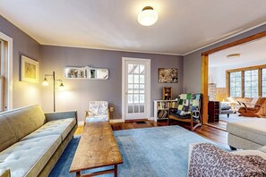 Una sala de estar acogedora con un sofá, una mesa de madera y una estantería.
