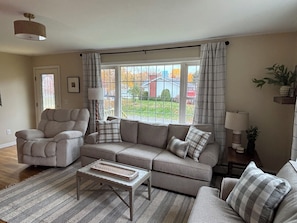 A living room with a sofa, armchair, and a coffee table.