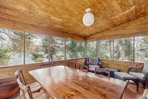 Ein Holzinterieur mit einem großen Tisch, Stühlen und einer Couch.