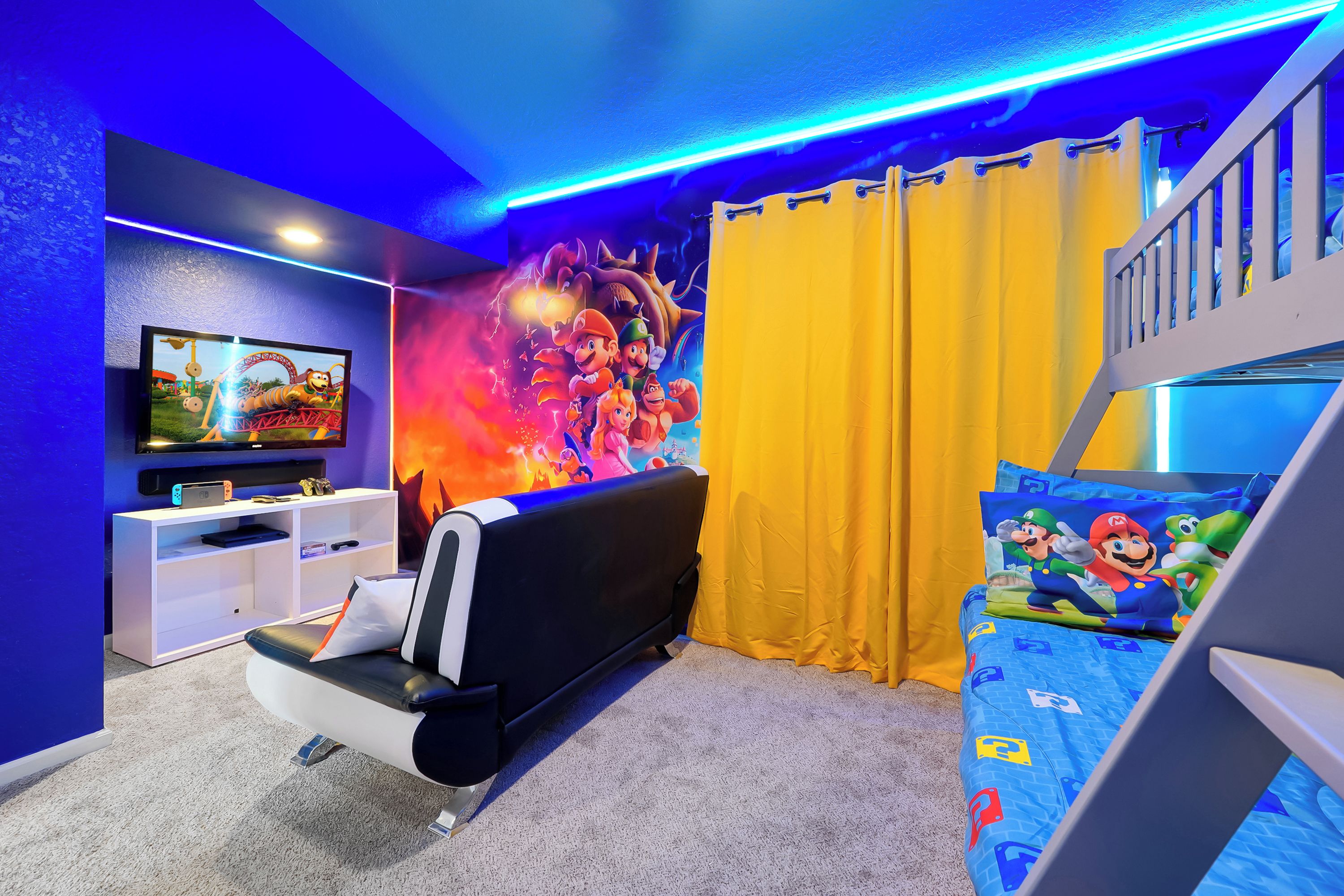 A bedroom with a bunk bed, a flat-screen TV, a wall mural, and a ceiling light fixture.