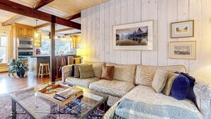 A living room with a sofa, coffee table, and framed pictures on the wall.