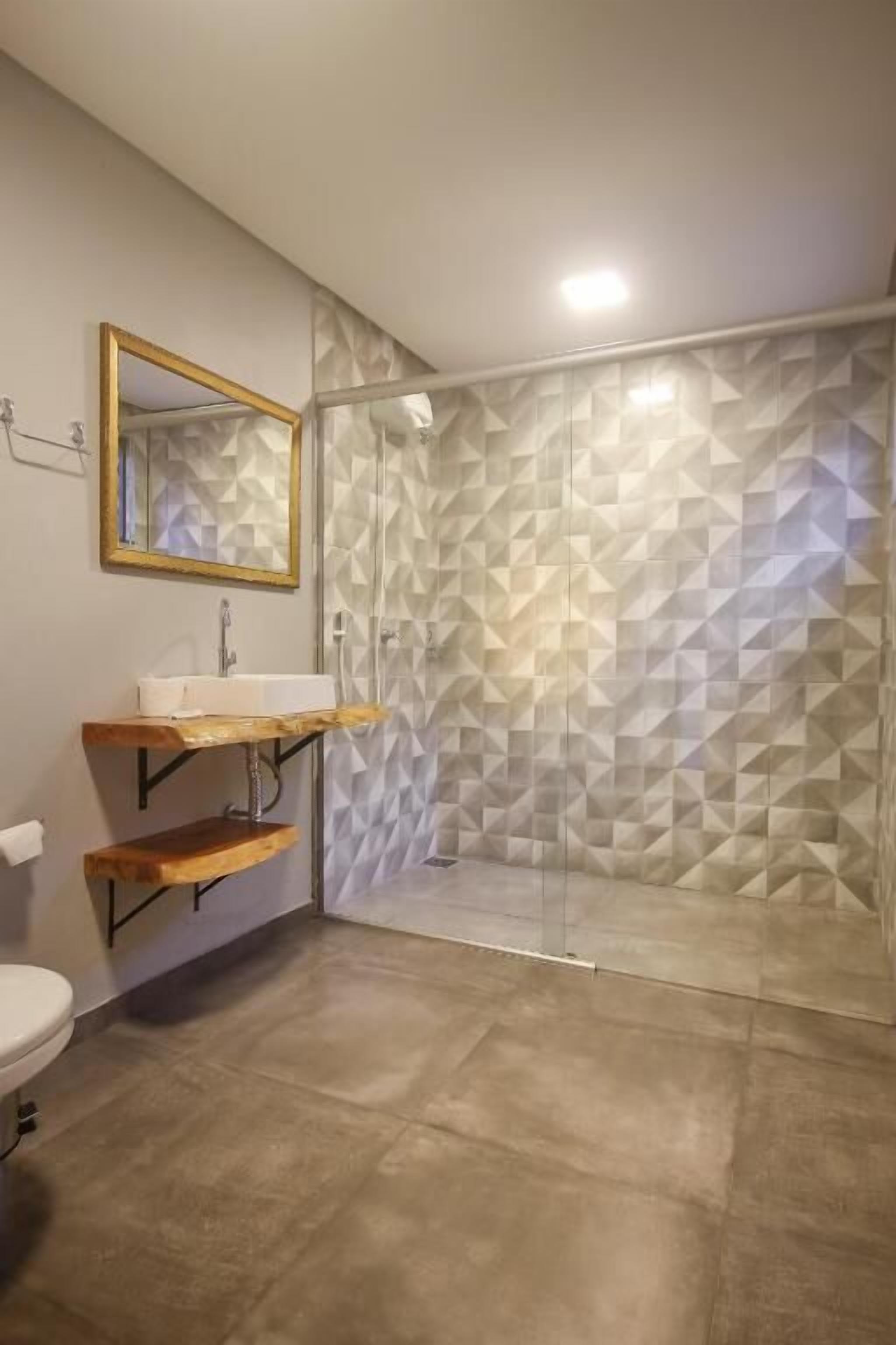 Luxe tweepersoonskamer | Badkamer | Een douche, een haardroger, handdoeken, zeep