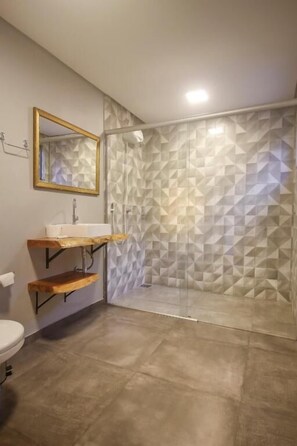 Luxe tweepersoonskamer | Badkamer | Een douche, een haardroger, handdoeken, zeep