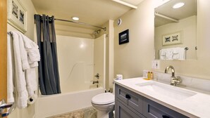 Et badeværelse med badekar, toilet og håndvask.