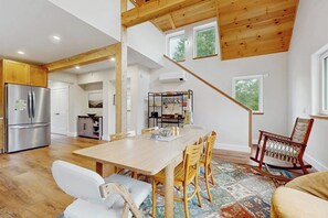 A spacious kitchen with a wooden ceiling, a dining area with a large table and chairs, and a view of the outdoors through a window. - Beautiful house w/ mountain view, balcony, grill, central a/c, close to skiing (Ludlow)