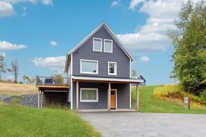 A two-story house with a garage, a covered porch, and a small deck. - Beautiful house w/ mountain view, balcony, grill, central a/c, close to skiing (Ludlow)