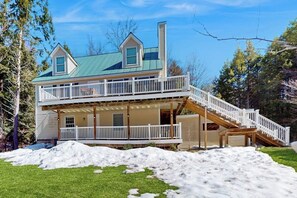 A two-story house with a balcony and a covered porch.