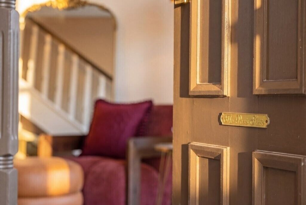 Una porta con una targa di ottone che recita 'The Paris Suite'.