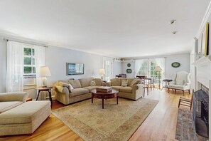 A living room with a sectional sofa, a coffee table, and a fireplace. - Spacious village house, dog-friendly, patio, fireplace, a/c, air hockey, w/d (Manchester)