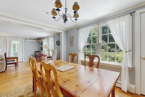 A dining room with a wooden table, chairs, and a chandelier. - Spacious village house, dog-friendly, patio, fireplace, a/c, air hockey, w/d (Manchester)